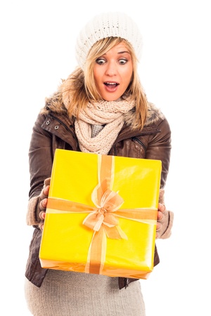Young happy surprised woman holding yellow gift box, isolated on white background.の写真素材