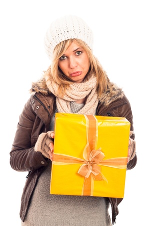 Unhappy disappointed sad woman holding yellow gift box, isolated on white background.の写真素材