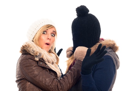 Two funny women in winter clothes having fun, isolated on white background.の写真素材