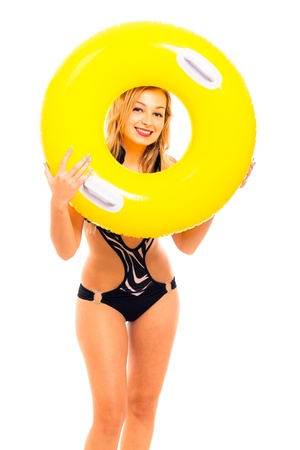 Portrait of young beautiful happy woman in swimsuit holding yellow rubber ring, isolated on white background.の写真素材