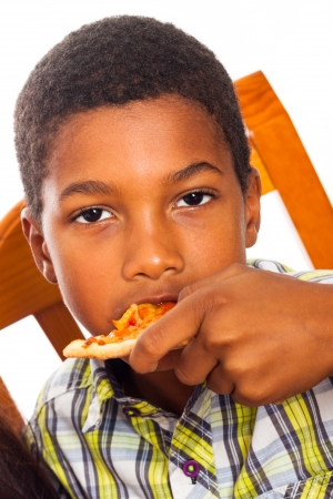 Close up of little boy eating pizza.の写真素材