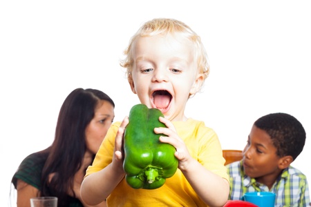 Funny happy child boy going to eat big green pepper, isolated on white background with copy space.の写真素材