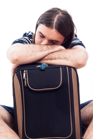 Tired traveler tourist man sleeping on luggage, isolated on white background.の写真素材