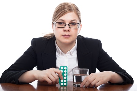Serious business woman with pills and glass of water, isolated on white background.の写真素材