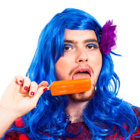 Transvestite man in blue wig licking ice pop, isolated on white background.の写真素材