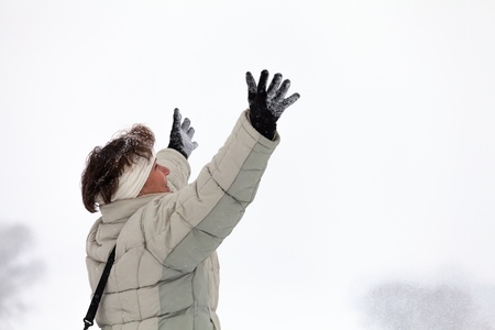 Ecstatic happy middle aged woman enjoying winter outdoors.の写真素材