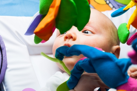 Detail of cute baby boy in bed with toys.の写真素材