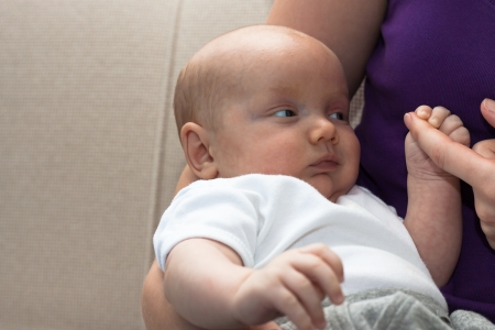 Close up of cute baby boy holding his mother finger.の写真素材