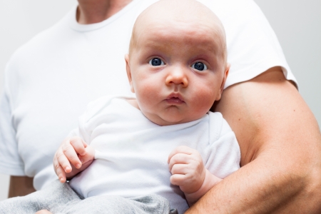 Close up of cute baby boy and male father arm.の写真素材