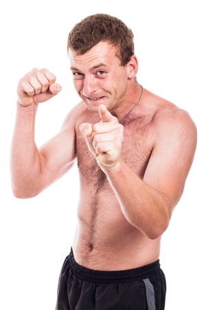 Young furious shirtless man showing fist and pointing at you, isolated on white backgroundの写真素材