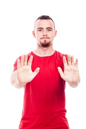 Defensive man in red t-shirt gesturing stop, isolated on white backgroundの写真素材