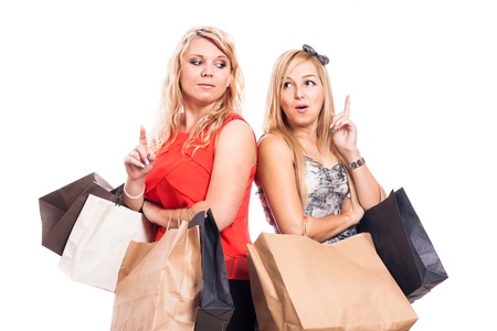 Excited girls holding shopping bags and pointing up, isolated on white backgroundの写真素材
