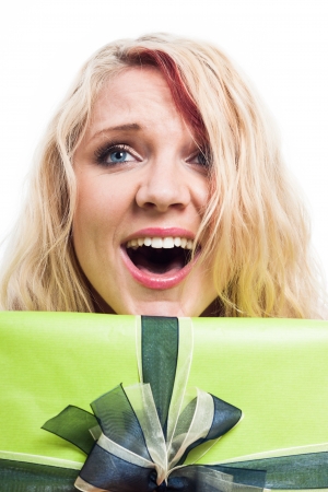 Closeup of surprised blond woman and green gift box, isolated on white backgroundの写真素材