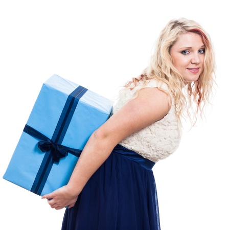 Young woman carrying big blue gift box, isolated on white backgroundの写真素材