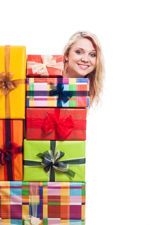 Happy woman hiding behind many colorful gift boxes, isolated on white backgroundの写真素材