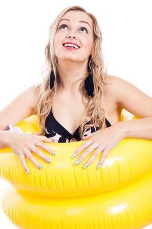 Ecstatic girl in swimsuit with two yellow rubber rings looking up, isolated on white backgroundの写真素材