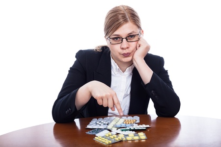 Serious business woman pointing at pills, isolated on white background.の写真素材