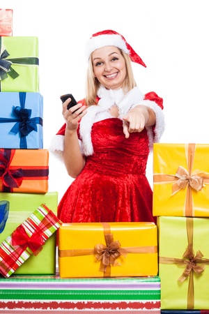 Happy woman in Christmas costume holding phone and pointing at you, isolated on white background.の写真素材