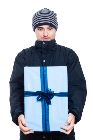Surprised man in winter jacket holding big present, isolated on white background.の写真素材