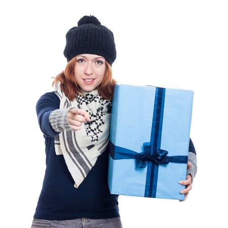 Winter woman holding big present and pointing at you, isolated on white background.の写真素材