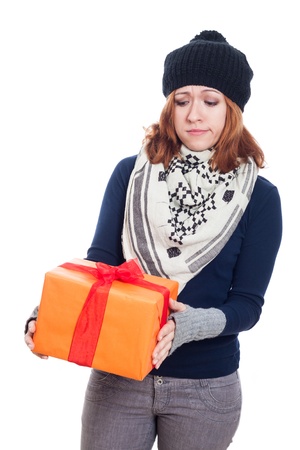 Sad winter woman looking at present, isolated on white background.の写真素材