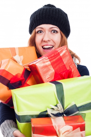 Ecstatic woman in winter hat holding many presents, isolated on white background.の写真素材
