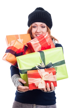 Satisfied woman in winter hat holding many presents, isolated on white background.の写真素材