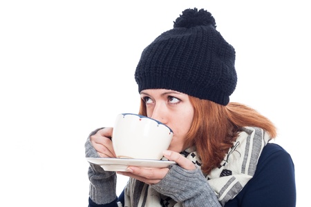 Woman in winter hat drinking hot tea or coffee, isolated on white background.の写真素材