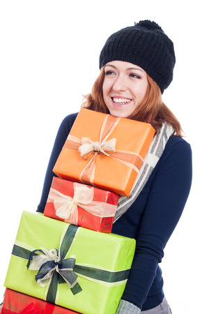 Happy woman in winter hat holding many presents, isolated on white background.の写真素材