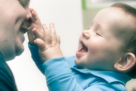 Closeup of happy child boy playing with his daddy.の写真素材