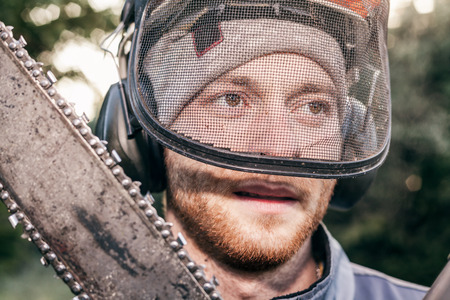Portrait of professional gardener with chainsaw.の写真素材