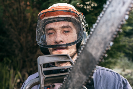 Portrait of professional gardener with chainsaw.の写真素材