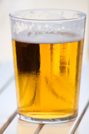 Close up of glass of fresh beer on table.の写真素材