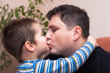 Closeup of happy father kissing his child boyの写真素材