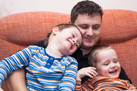 Closeup of happy children boys and daddy having fun on sofa at homeの写真素材