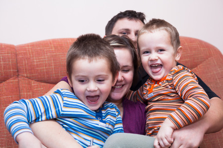 Happy parents with children having fun at homeの写真素材