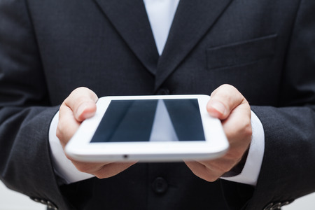 Detail of businessman holding digital tablet.の写真素材