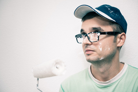 Young man decorating interior with paint roller.の写真素材