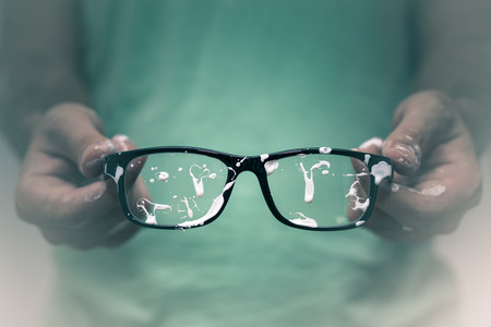 Creative vision concept. Closeup of creative man showing his stained eyeglasses.の写真素材