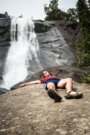 A man relaxing next to waterfall in Langkawi, Malaysia.の写真素材