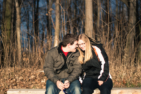 Two young happy people sitting on park benchの写真素材