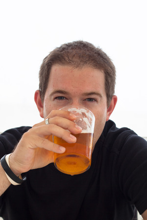 Close up of young man drinking beer.の写真素材