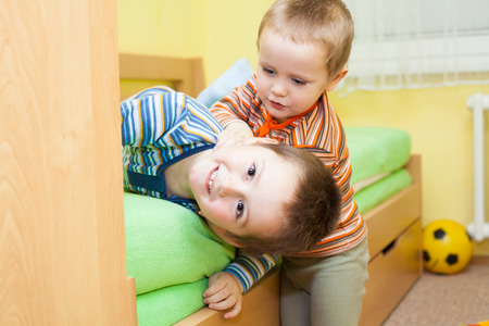 Two children playing together and having fun at homeの写真素材