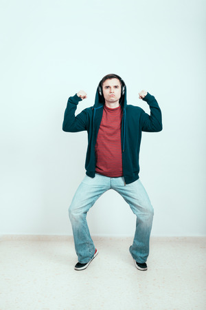 Self-confident man in hoodie with headphones showing his power.の写真素材