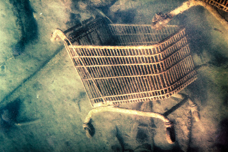 Abstract creative photo of shopping trolley discarded on the sea bottom の写真素材