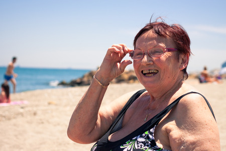 Portrait of happy senior woman relaxing on the beach.の写真素材