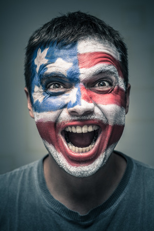 Portrait of exited man with US flag painted on face.の写真素材