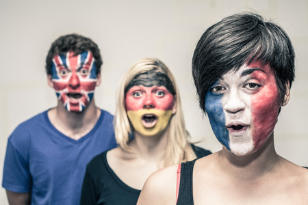 Group of surprised happy people with painted flags on their faces.の写真素材