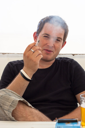 Close up of young man smoking cigarette.の写真素材