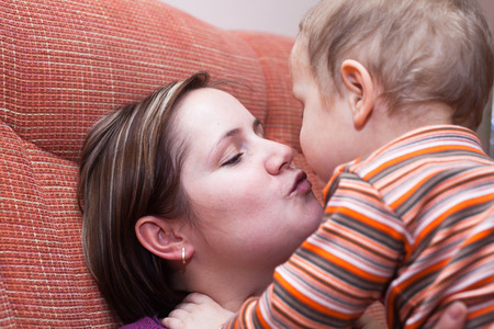 Closeup of happy mother kissing her child boyの写真素材